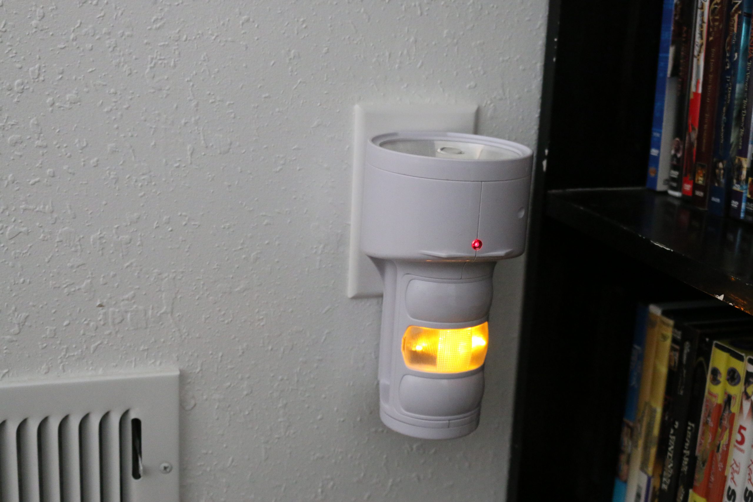 Emergency flashlight plugged into wall electrical outlet.
