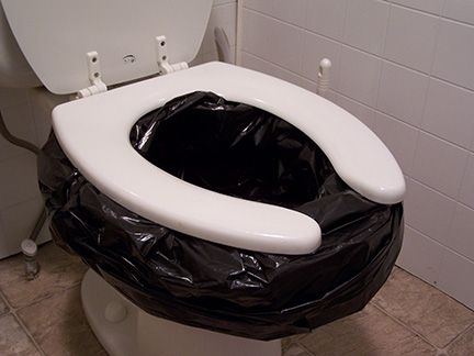 Toilet with garbage bag lining the bowl