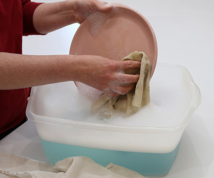wash dishes by hand in wash basin